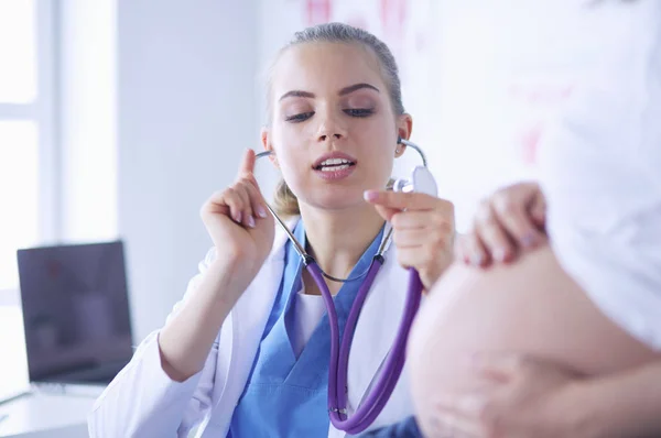 Giovane medico donna esaminando donna incinta presso la clinica. — Foto Stock