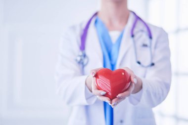 Kalbi tutan steteskoplu bir doktor, beyaz arka planda izole edilmiş.