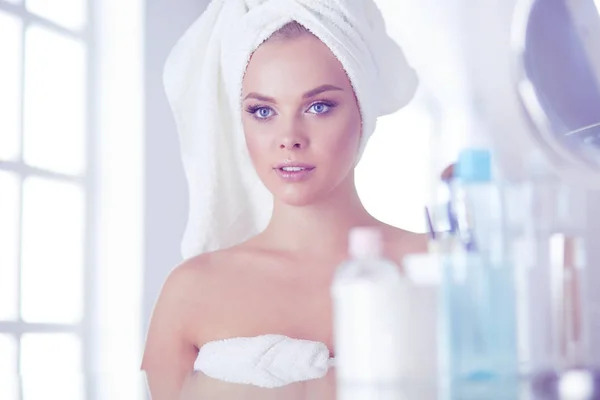 Jonge vrouw in badjas op zoek in badkamer spiegel — Stockfoto