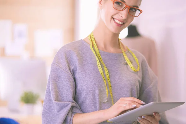 Mooie jonge vrouw werken op digitale tablet en glimlachen terwijl zitten op haar werkplek — Stockfoto