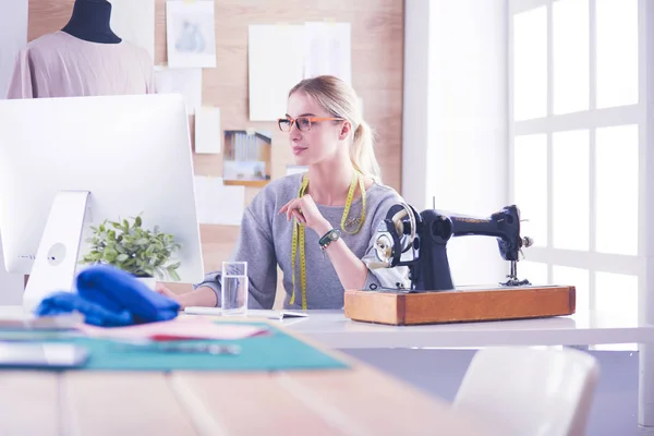 Schönes junges Mädchen in einer Fabrik mit einer Nähmaschine am Tisch — Stockfoto