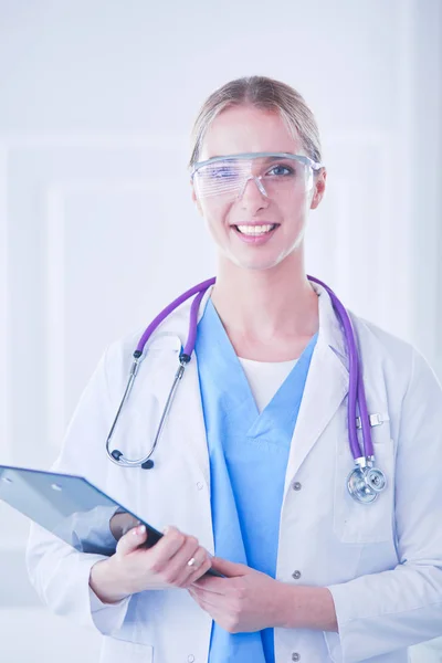 Улыбающаяся доктор женщина в синей форме со стетоскопом показывает хорошо знак жеста руки изолированы на белом фоне — стоковое фото