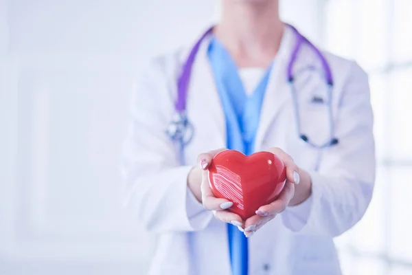 Médico com estetoscópio segurando coração, isolado em fundo branco — Fotografia de Stock