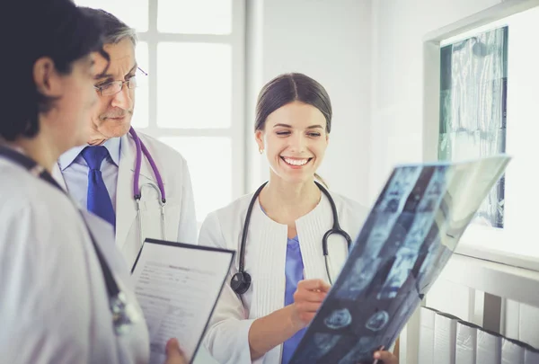 Médecins souriants discutant du diagnostic des patients regardant les rayons X dans un hôpital — Photo