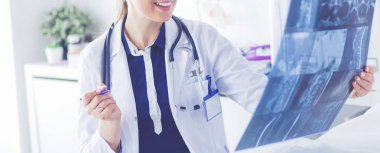 Genç ve çekici bayan doktor röntgen görüntülerine bakıyor.