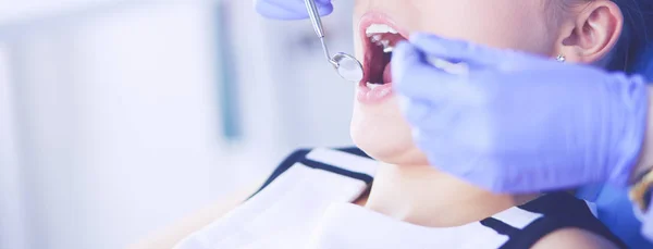 Mujer joven con la boca abierta examinando la inspección dental en el consultorio del dentista. —  Fotos de Stock