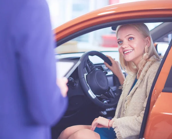Όμορφη νεαρή γυναίκα αγοράζει ένα αυτοκίνητο στην αντιπροσωπεία σαλούν — Φωτογραφία Αρχείου
