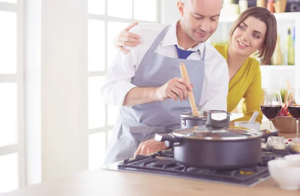 Atractiva pareja enamorada de cocinar y abre el vino en la cocina mientras cocinan la cena para una velada romántica —  Fotos de Stock