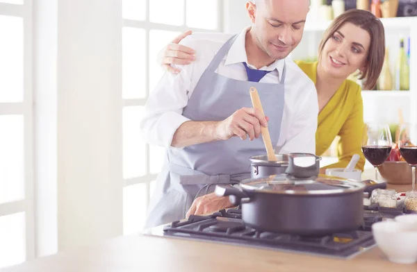 Casal atraente no amor cozinhar e abre o vinho na cozinha, enquanto eles cozinham o jantar para uma noite romântica — Fotografia de Stock