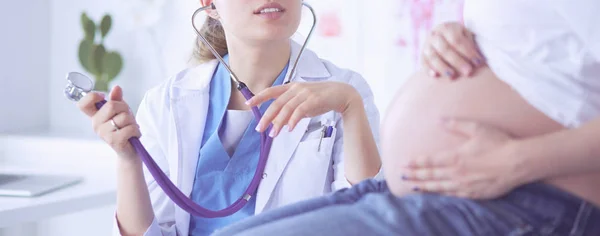 Νεαρή γυναίκα γιατρός με στηθοσκόπιο μιλάει με έγκυο γυναίκα στο νοσοκομείο. — Φωτογραφία Αρχείου