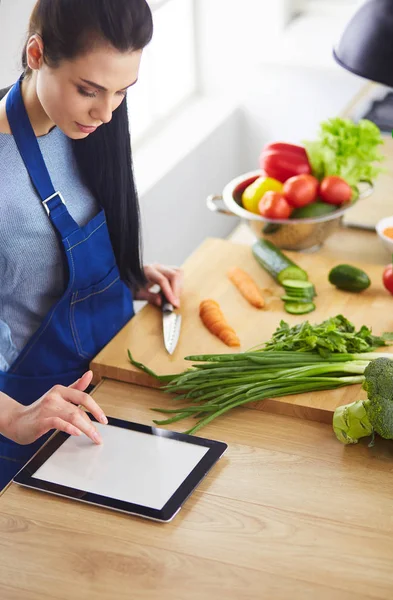 Junge Frau schneidet Gemüse in Küche zu Hause — Stockfoto