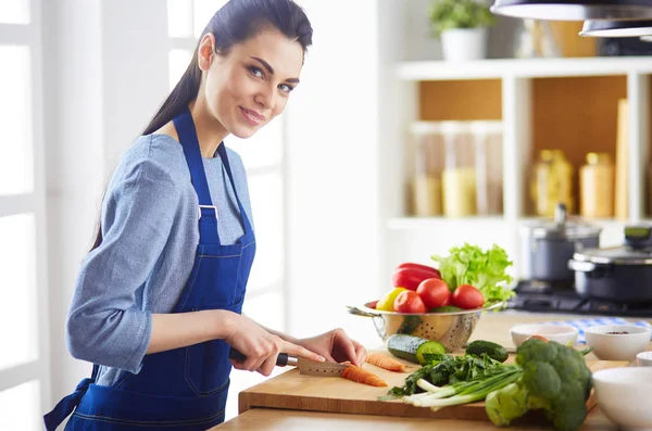 Mujer joven cortando verduras en la cocina en casa —  Fotos de Stock