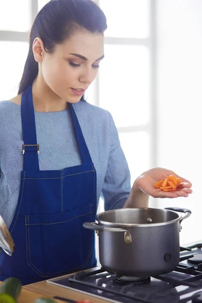 Vaření žena v kuchyni s dřevěnou lžičkou — Stock fotografie
