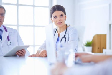 Doktorlar hastane konferans odasında birbirlerine danışıyorlar.