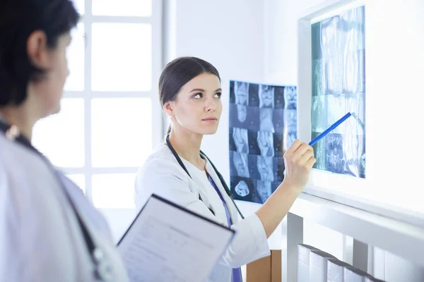 Twee vrouwelijke artsen wijzend op röntgenstralen in een ziekenhuis — Stockfoto