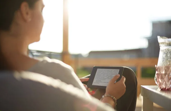 Giovane donna sorridente seduta sul divano con touchpad . — Foto Stock