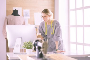 Moda tasarımcısı kadın dikiş makinesiyle dikiş dikiyor