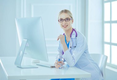 Modern bir hastanede masa başında çalışan bir kadın doktor.