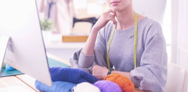 Moda tasarımcısı stüdyoda tablet bilgisayar kullanıyor.