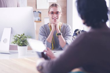 Kadın terzi, dikiş atölyesindeki özel dikim elbise hakkında potansiyel müşteriyle iletişim kuruyor.