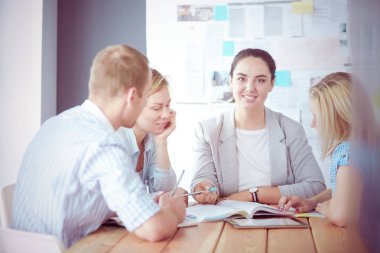 Masada kitaplarla çalışan gençler. Güzel kadınlar ve erkekler birlikte çalışıyor..