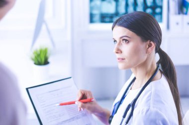 Güzel bayan doktor bir hastaya tıbbi tedaviyi açıklıyor.