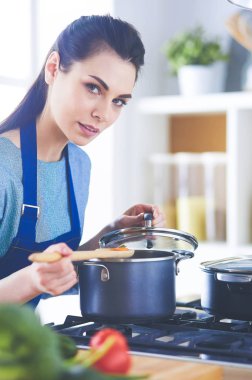 Mutfakta ahşap kaşıkla yemek pişiren kadın