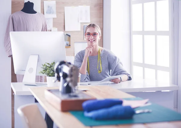 Mooi jong meisje in een fabriek met een naaimachine aan de tafel — Stockfoto