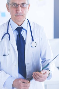 Erkek doktor hastanedeki panoya notlar yazıyor.