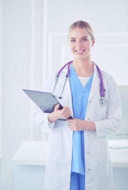 Kadın doktor hastanede dosyayla bekliyor.