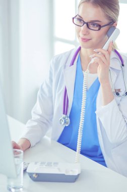 Ofiste cep telefonunu kullanan kadın doktorun portresi.