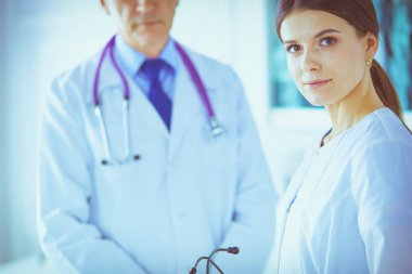 İki doktor hastanedeki konferans odasında, biri kameraya bakıyor.