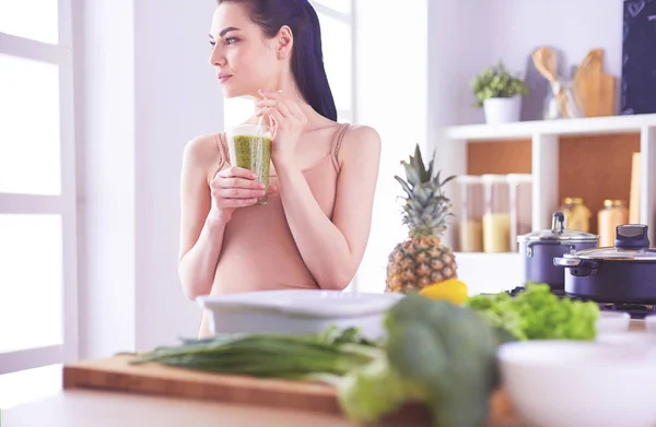 Giovane donna con vetro di frullato sano saporito a tavola in cucina — Foto Stock