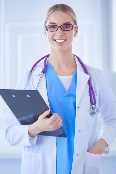 Uśmiechnięta lekarka z folderem na stojąco — Zdjęcie stockowe