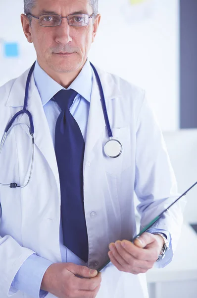 Man dokter schrijft notities op het klembord in het ziekenhuis — Stockfoto