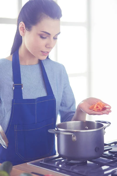 Cozinhar mulher na cozinha com colher de madeira — Fotografia de Stock