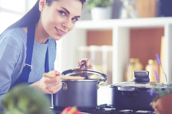 Cozinhar mulher na cozinha com colher de madeira — Fotografia de Stock