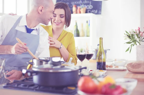 Atractiva pareja enamorada de cocinar y abre el vino en la cocina mientras cocinan la cena para una velada romántica —  Fotos de Stock