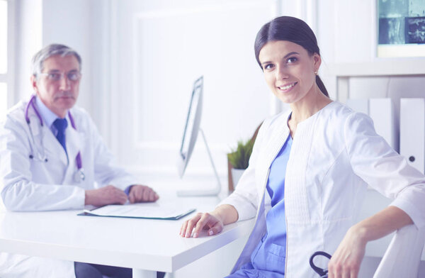 Two doctors smiling in consulting room in hospital