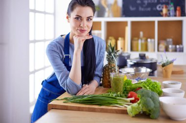 Mutfakta bir sepet taze sebzeyle genç.