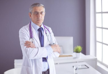 Parlak ofisinde gülümseyen bir doktorun portresi.