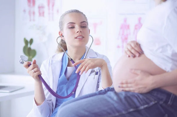 Mladá žena lékař se stetoskopem mluvit s těhotnou ženou v nemocnici. — Stock fotografie