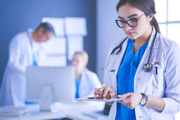 Female doctor using tablet computer in hospital lobby