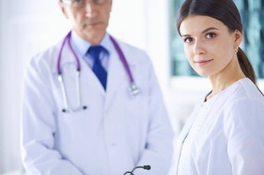 İki doktor hastanedeki konferans odasında, biri kameraya bakıyor.