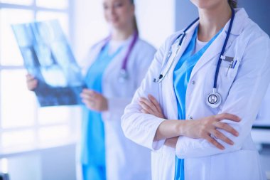 Doktorların yakın plan çekimleri ve arka planda röntgen olan meslektaşlar..