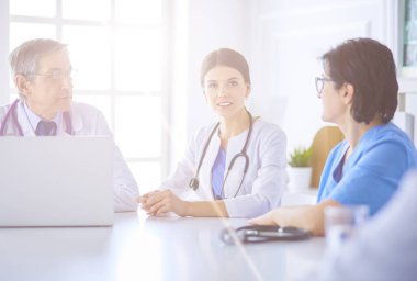 Doktorlar hastane konferans odasında birbirlerine danışıyorlar.