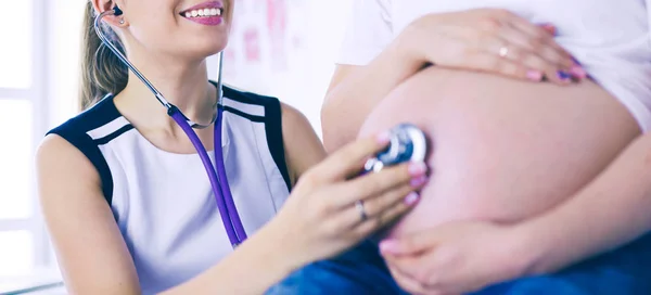 Doctora joven examinando a una mujer embarazada en la clínica. —  Fotos de Stock