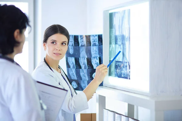 Two female doctors pointing at x-rays in a hospital — Stock Photo, Image