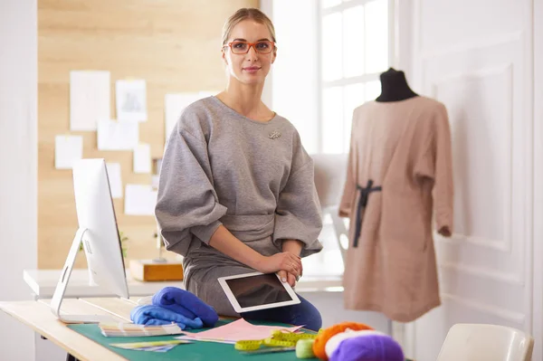 Beautiful fashion woman designer standing in studio