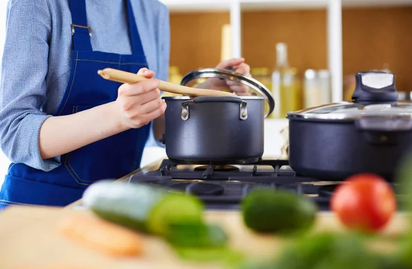 Mujer cocinera en cocina con cuchara de madera — Foto de Stock